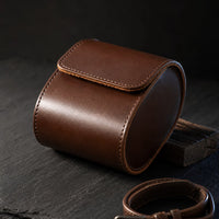 Brown leather watch travel case held in hand, lifestyle shot