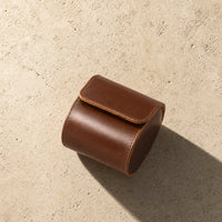 Brown leather watch travel case on desk, lifestyle shot