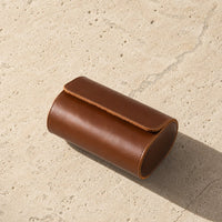 Brown leather watch travel case with watch inside, lifestyle shot